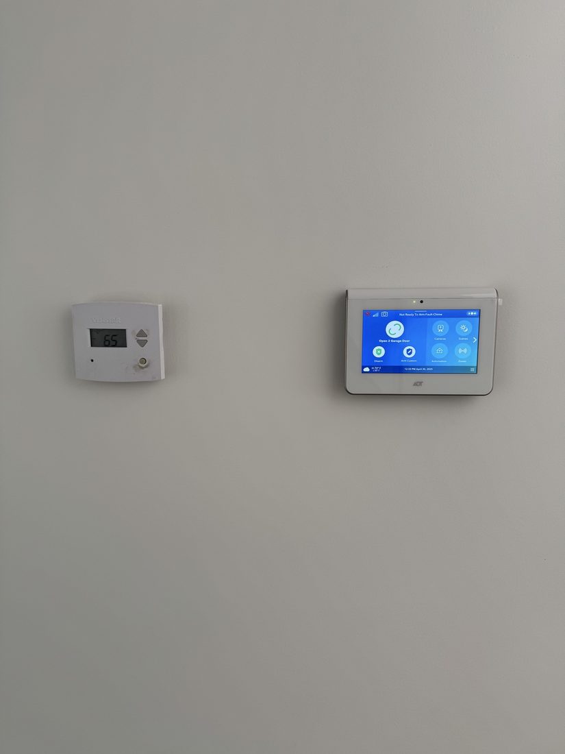New ADT touchscreen installed beside the home’s original thermostat