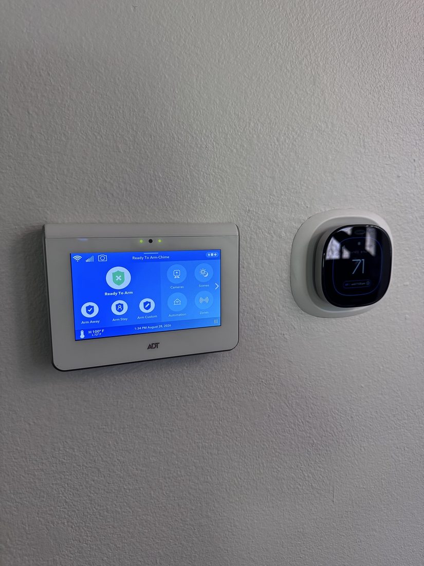ADT panel installed beside a smart thermostat